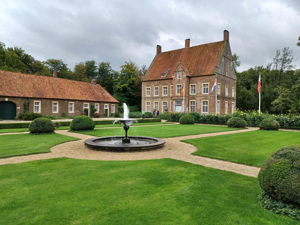 Blick aus dem Garten über den Brunnen auf das Haupthaus von Haus Welbergen